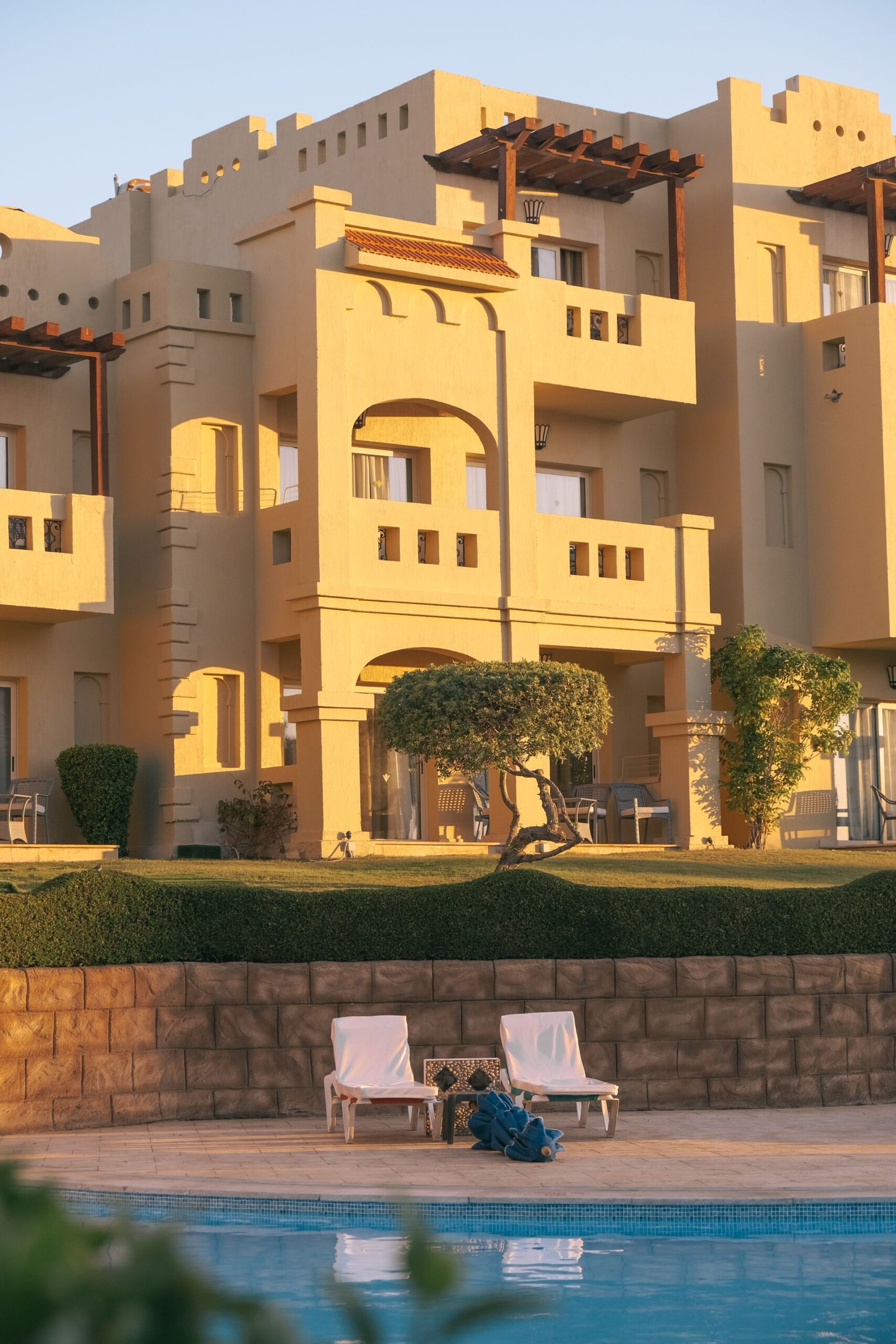 Jardín mediterráneo con piscina infinita al atardecer